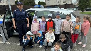 spotkanie policjantów z dziećmi ze szkoły podstawowej nr 5 w Przemyślu. Zdjęcie grupowe na tle radiowozu.