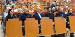 uczestnicy podczas debaty siedzą na widowni auli,