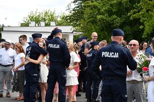 zdjęcia ze ślubowania nowo przyjętych policjantów. na placu policjanci otrzymują gratulacje od swoich rodzin