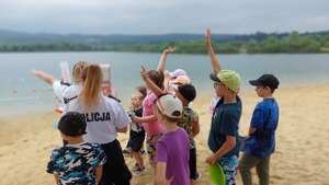 dzieci na plaży rozmawiają z policjantkami