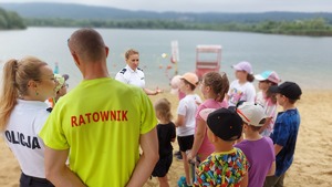 policjantki i ratownik prowadzą rozmowy z dziećmi na plaży