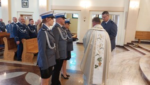 zdjęcia z uroczystości Święta Policji w Komendzie Miejskiej Policji w Przemyślu. Policjanci wręczają księdzu Prałatowi Januszowi Mączka- kapelanowi przemyskiej komendy   dary podczas  Mszy Świętej.