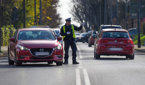 policjant umundurowany kieruje ruchem na drodze