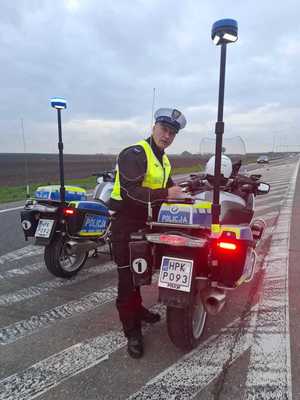 Zdjęcie kolorowe przedstawia dwa motocykle policyjne stojące na jezdni