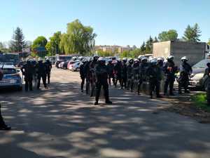 Zdjęcie kolorowe przedstawia policjantów zabezpieczających przejście kibiców na mecz piłki nożnej w miejscowości Przemyśl