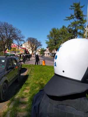 Zdjęcie kolorowe przedstawia policjantów zabezpieczających przejście kibiców na mecz piłki nożnej w miejscowości Przemyśl