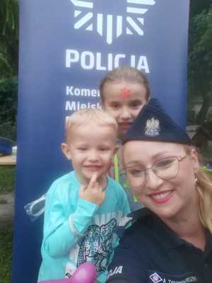 Zdjęcie z policjanta z dziećmi z pikniku rodzinnego.