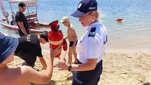 policjanci na plaży Ostrów podczas działań &quot;Kręci mnie bezpieczeństwo nad wodą&quot; z dziećmi