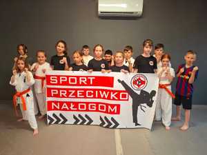 funkcjonariusze policji wraz z uczniami szkoły kartę w czasie prowadzonych prelekcji  w miejscowości Orły