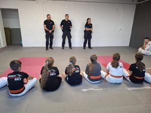 funkcjonariusze policji wraz z uczniami szkoły kartę w czasie prowadzonych prelekcji  w miejscowości Orły
